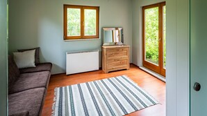 A room with a brown sofa, a white radiator, a wooden dresser, and a patterned rug. - Roso 3 bedroom modern country house (gmina Chynów)