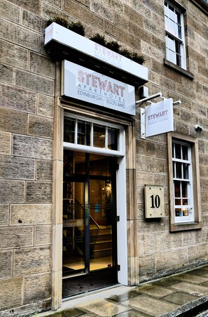 Una entrada de hotel con un letrero que dice "STEWART APART HOTEL EDINBURGH, SCOTLAND" y el número "10" en la pared.