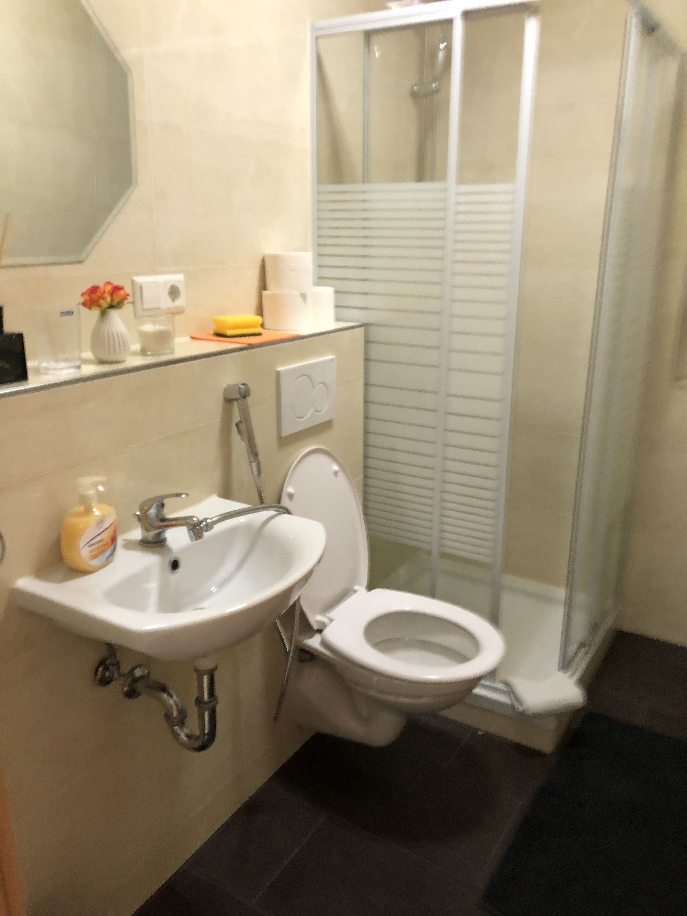 Un baño con lavamanos, inodoro y cabina de ducha de vidrio.