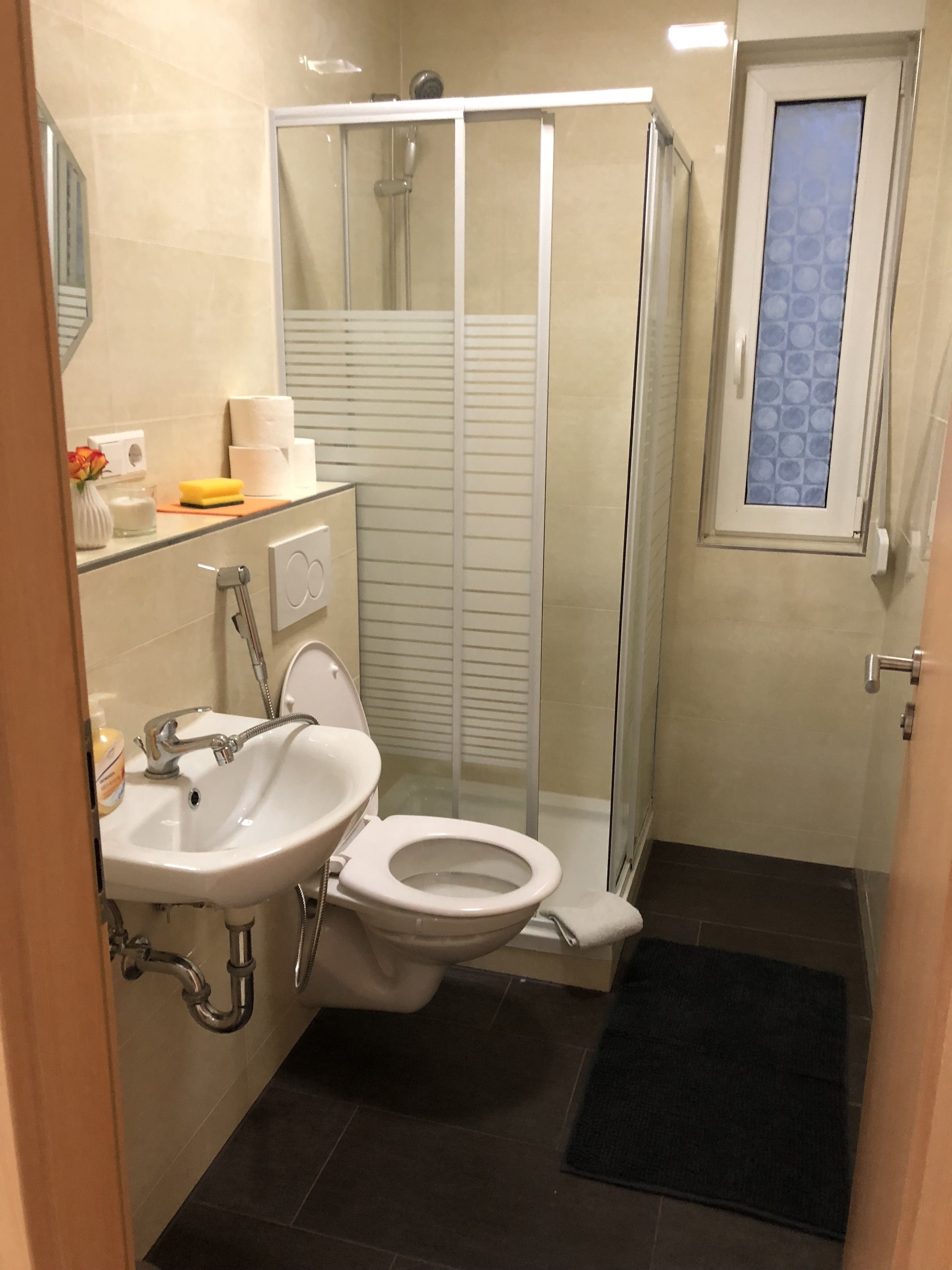 A bathroom with a toilet, sink, and shower.