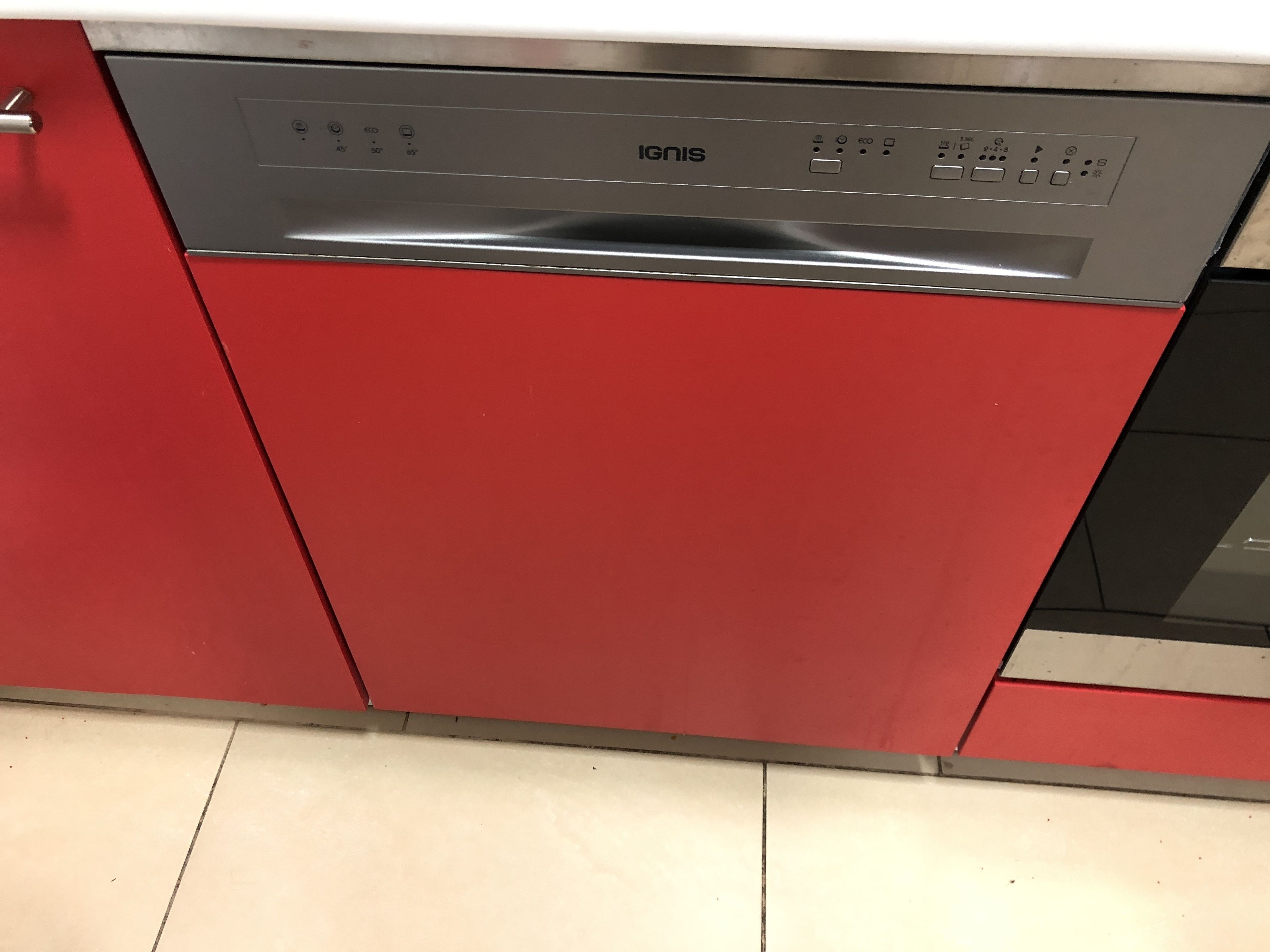 Een rode keuken met een ingebouwde vaatwasser.
