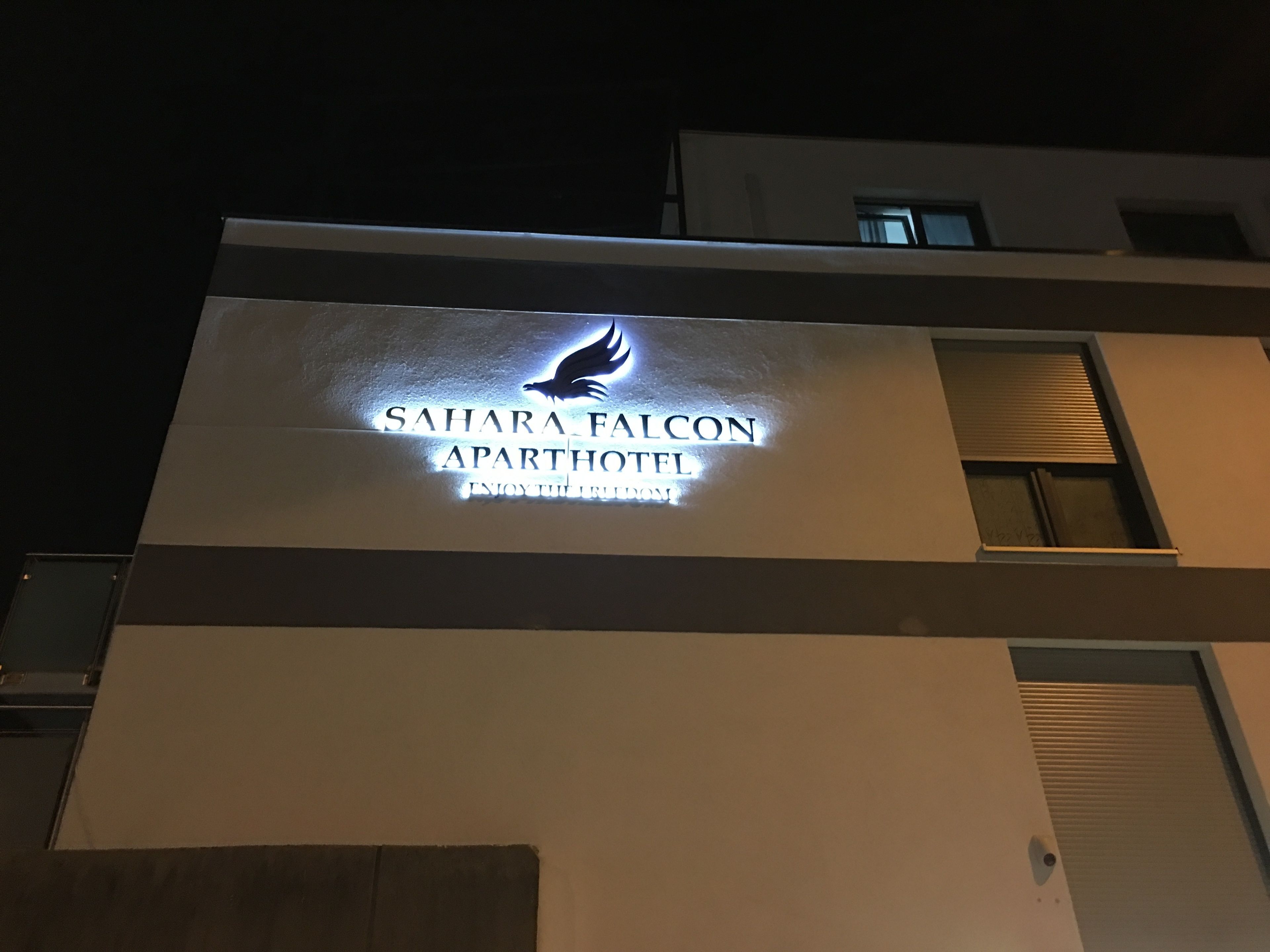 Sahara Falcon Apart Hotel -niminen hotelli, jonka kyltissä on linnun muotoinen logo.