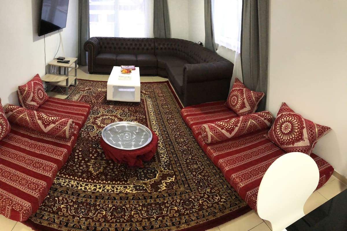 Un salon comprenant un canapé d’angle, une table basse et un tapis à motifs.