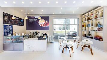 Ein modernes Café-Interieur mit einer Theke, einer Sitzgelegenheit und einem großen Fenster.