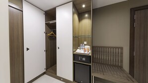 A hotel room with a wardrobe, a small refrigerator, a bed, and a bedside table. - Nooa Hotel Ras Al Khaimah (Ras Al Khaimah)