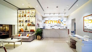 A modern hotel lobby with a reception desk, seating area, and a large plant. - Citymax Hotel Ras Al Khaimah (Ras Al Khaimah)