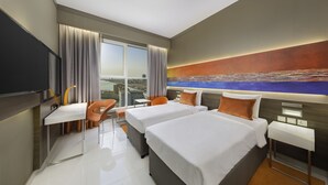 A modern hotel room with two beds, a desk, and a chair. - Citymax Hotel Ras Al Khaimah (Ras Al Khaimah)