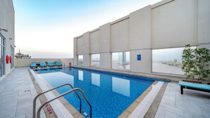 An indoor swimming pool with clear views of a cityscape through large windows. - Citymax Hotel Ras Al Khaimah (Ras Al Khaimah)