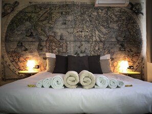 A bed with rolled towels and a large map on the wall behind it. - Francis B&B Superior (Trieste)