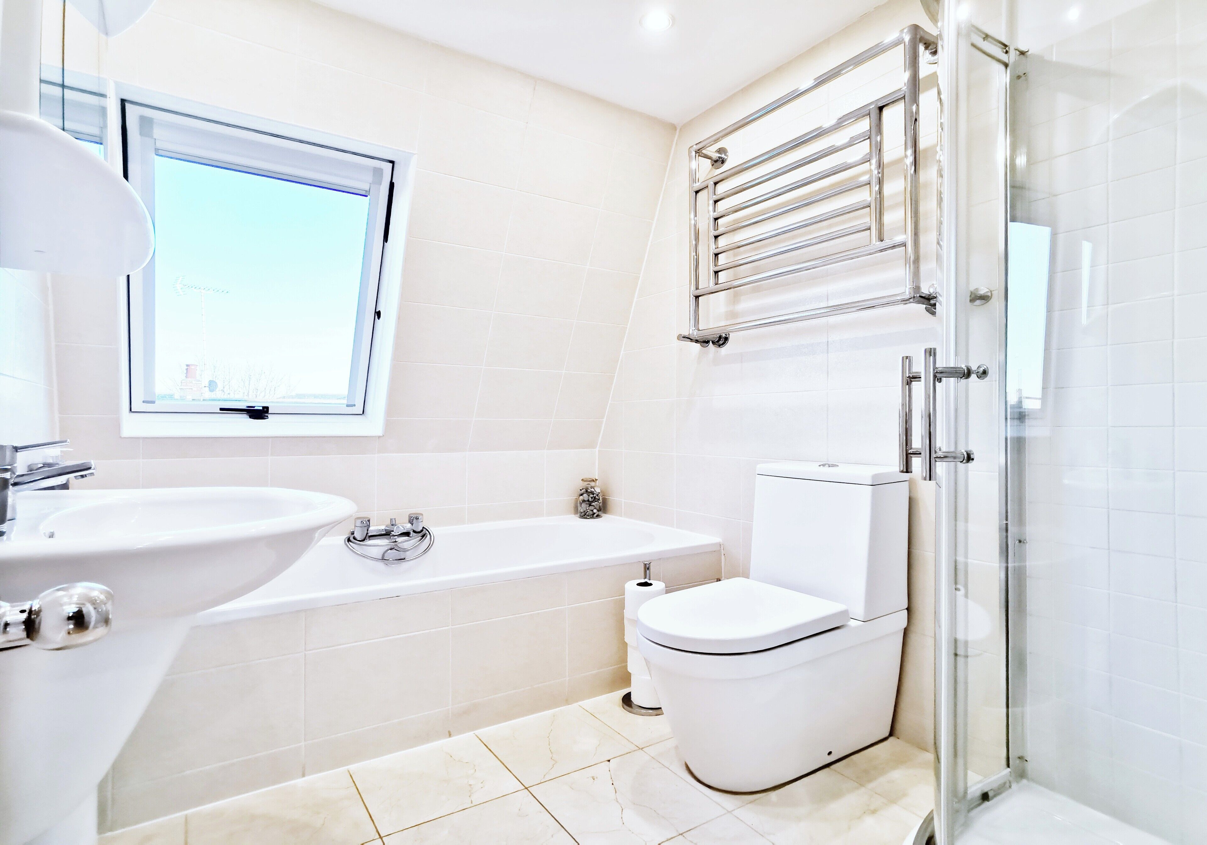 Un baño moderno con bañera, inodoro y cabina de ducha de vidrio.