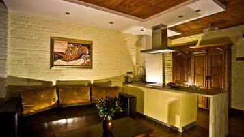 A modern kitchen with a wooden ceiling, a built-in island, and a brick wall.