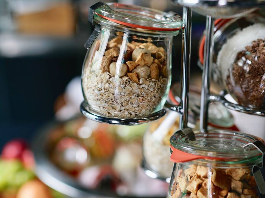 Una exposición de alimentos en frascos de vidrio sobre un pedestal.