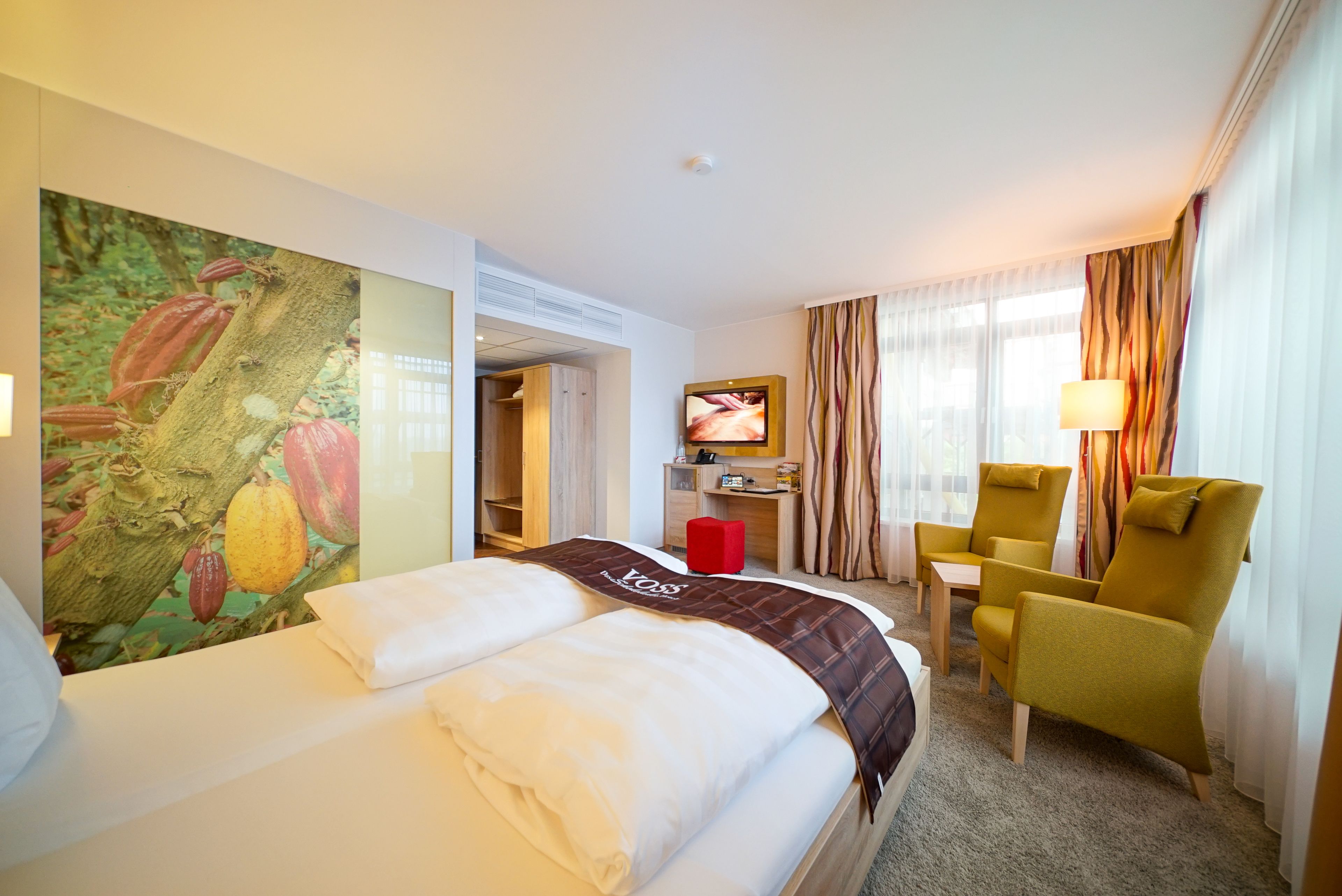 Une chambre d’hôtel avec un lit, une télévision, un bureau, une chaise et un grand tableau au mur.