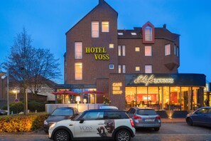 A hotel with a prominent sign reading "HOTEL VOSS" and a cafe lounge with a visible entrance. - Das Schokoladenhotel (Westerstede)