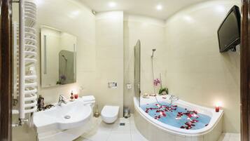 A modern bathroom with a bathtub, two sinks, a toilet, and a shower.