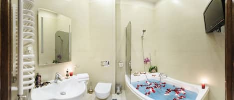 A modern bathroom with a bathtub, two sinks, a toilet, and a shower.
