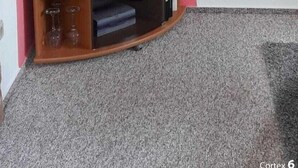 Un televisor de pantalla plana sobre un soporte de madera en una habitación con paredes rojas y un cuadro enmarcado.