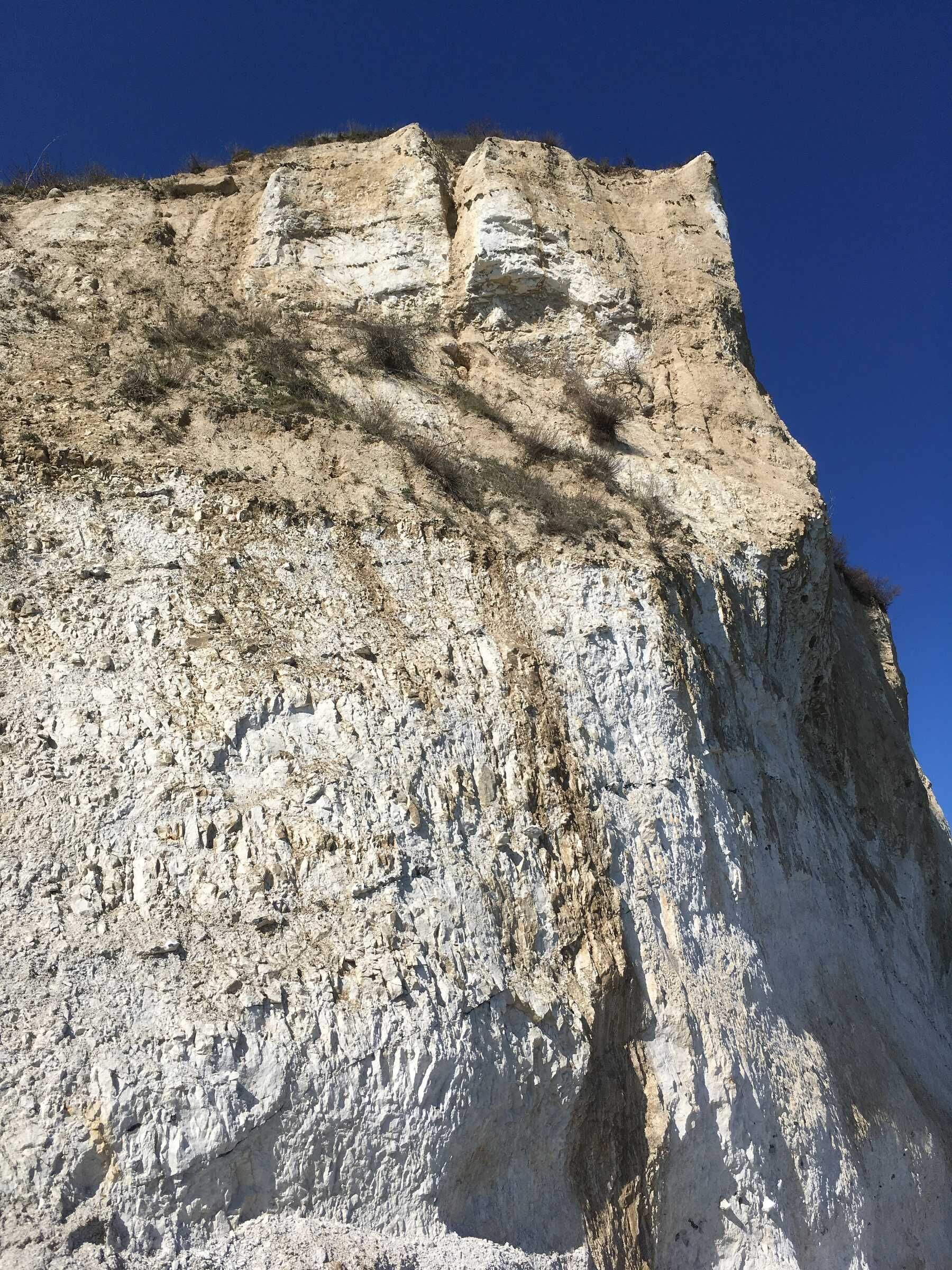 A large rock formation with a steep cliff face.