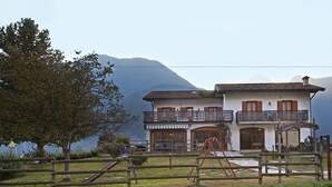 Un bâtiment à deux étages doté d’un balcon, d’une aire de jeux et offrant une vue sur les montagnes.