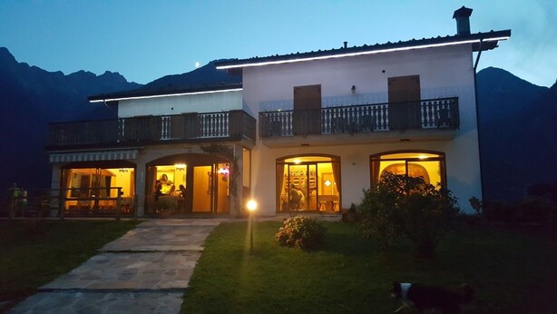Une maison à deux étages dotée d’un balcon, d’un porche et d’une entrée bien éclairée.
