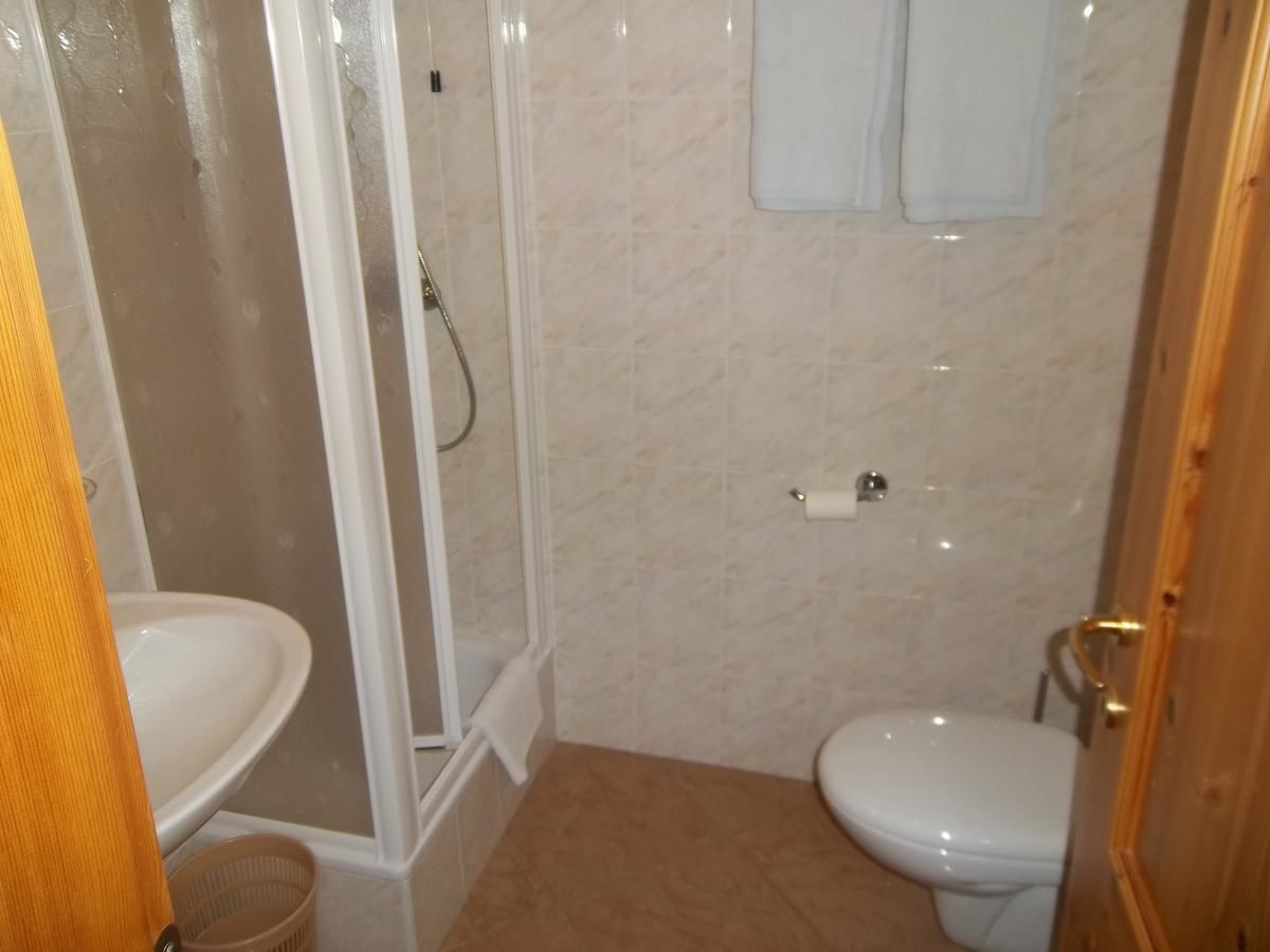 Un baño con cabina de ducha, inodoro y lavamanos.