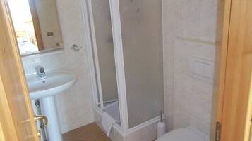 Une salle de bain avec une douche, un lavabo et des toilettes.