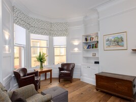 Apartamento, varias camas | Zona de estar | Una televisión, una chimenea