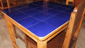 A wooden table with a blue-tiled top. - Sari Laut (Gili Meno)