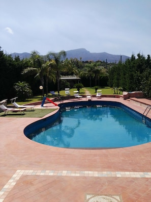 Una piscina al aire libre, tumbonas