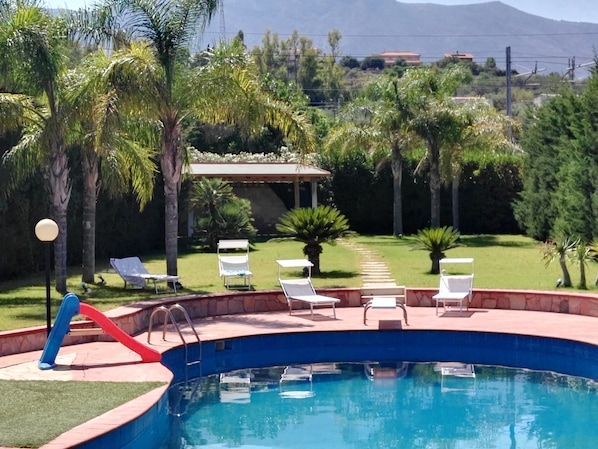 Una piscina al aire libre, tumbonas