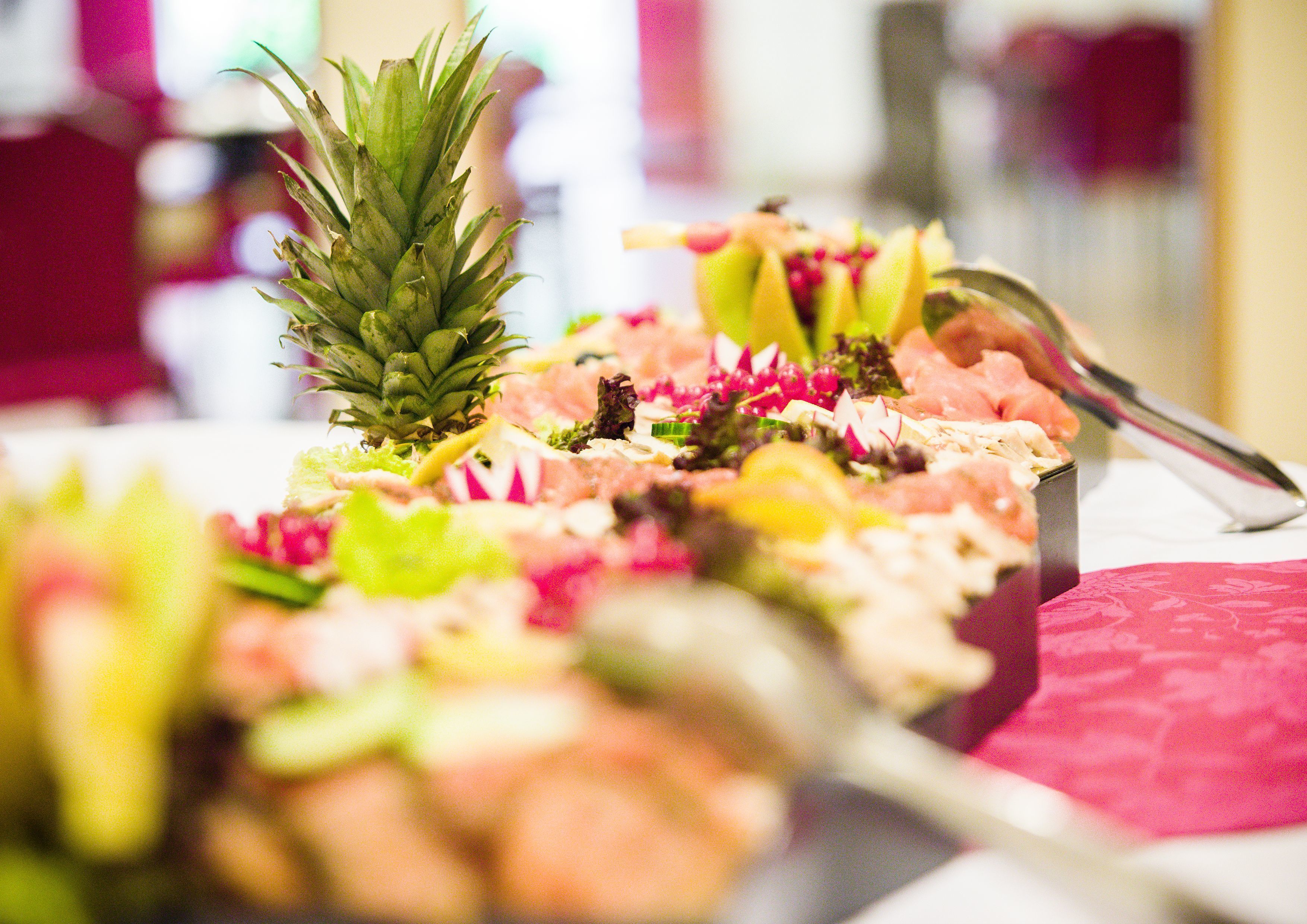 Close-up de um prato de comida com abacaxi e diversas coberturas coloridas.