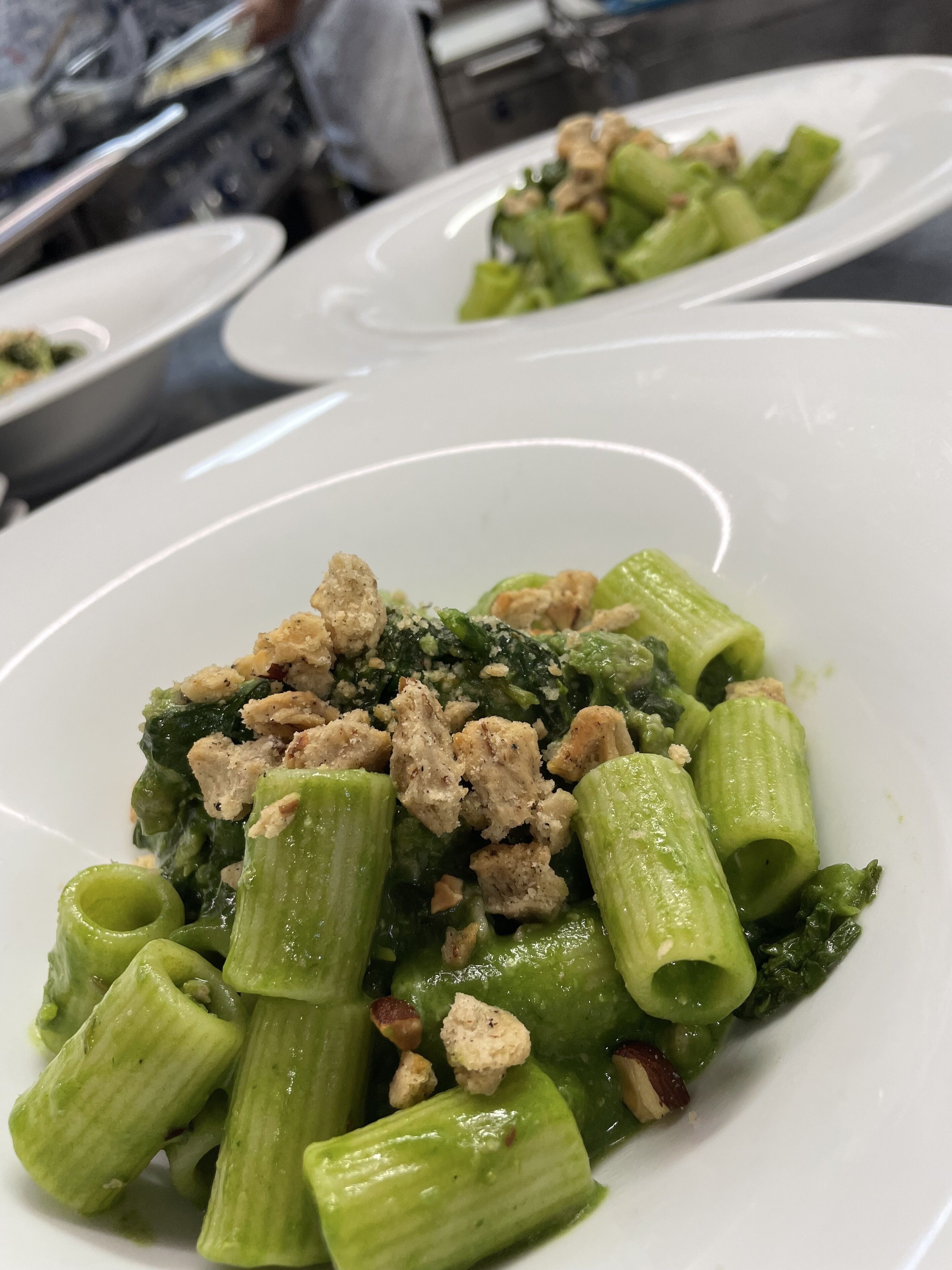 A plate of pasta with broccoli and croutons.