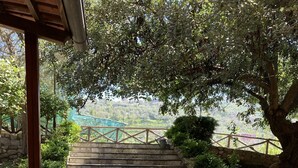 A stone staircase leading up to a covered area with a view of a distant landscape. - Nonno Luigino (Vico Equense)