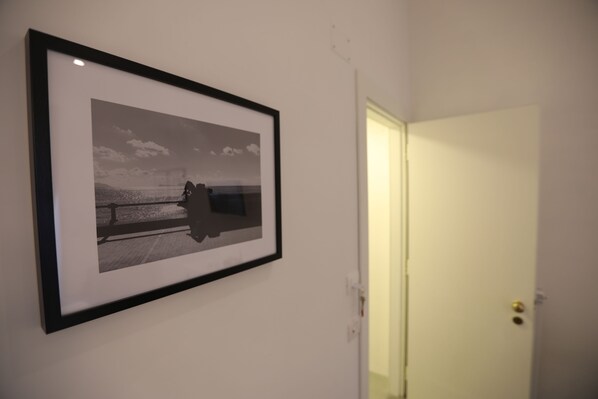 A framed photograph on a wall, a closed door, and a light switch.