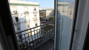 A balcony with a view of a city street, buildings, and a clear sky. - The Station Napoli (Naples)