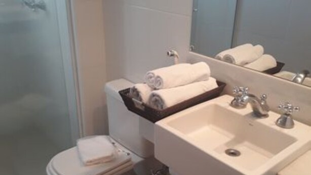 Une salle de bain avec des toilettes, un lavabo et un miroir.