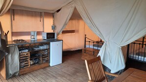 Une pièce confortable avec un coin cuisine, un lit à baldaquin et un plancher en bois.