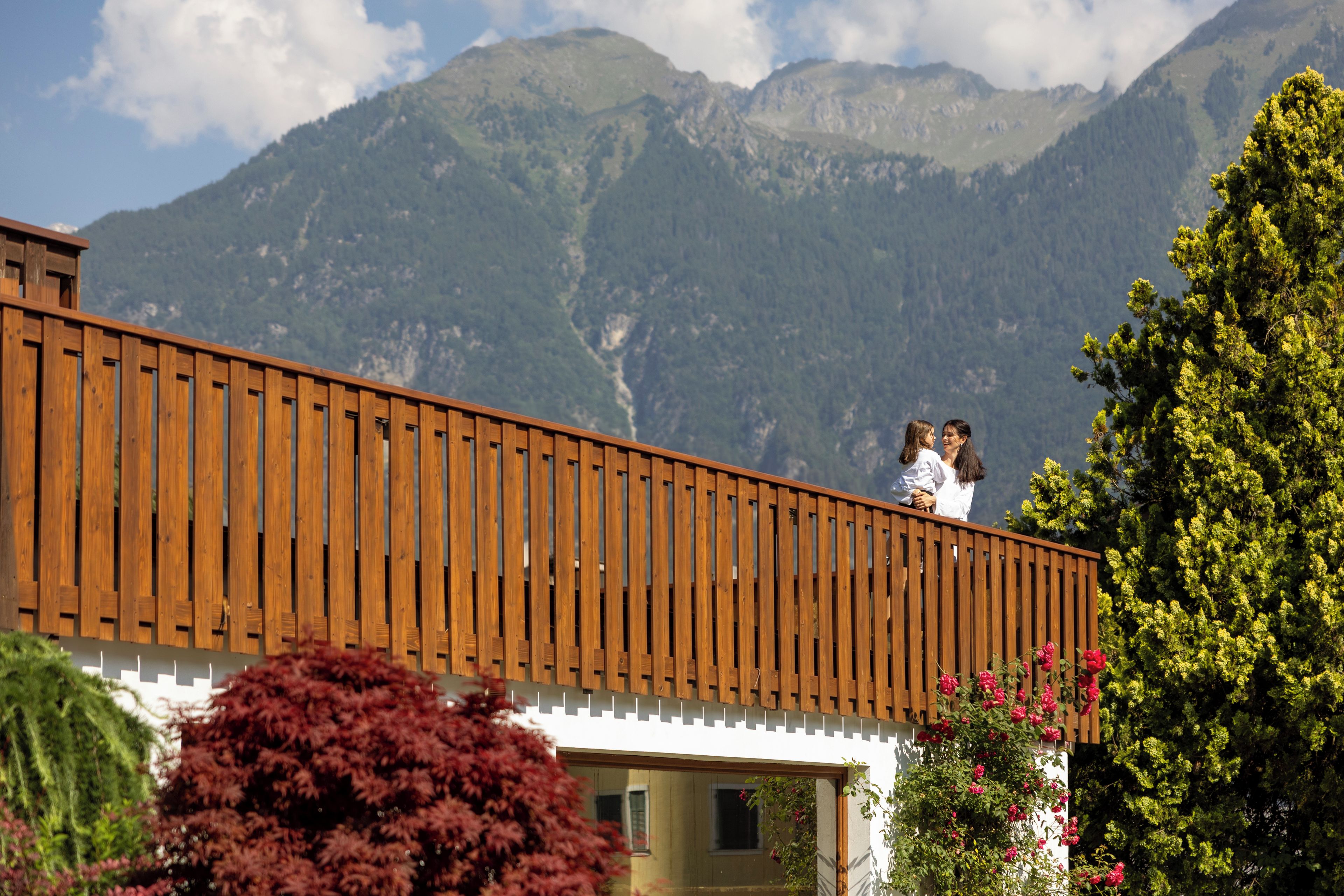 Un balcone in legno con vista su un paesaggio montuoso.