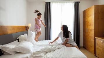 Una camera d'hotel con un letto, una testiera in legno, un comodino con una lampada e un armadio.