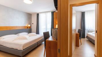 Ein Hotelzimmer mit einem Bett, einem Schreibtisch, einem Stuhl, einem Spiegel und einem Kleiderschrank.