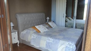Un dormitorio con cama, mesita de noche y armario.