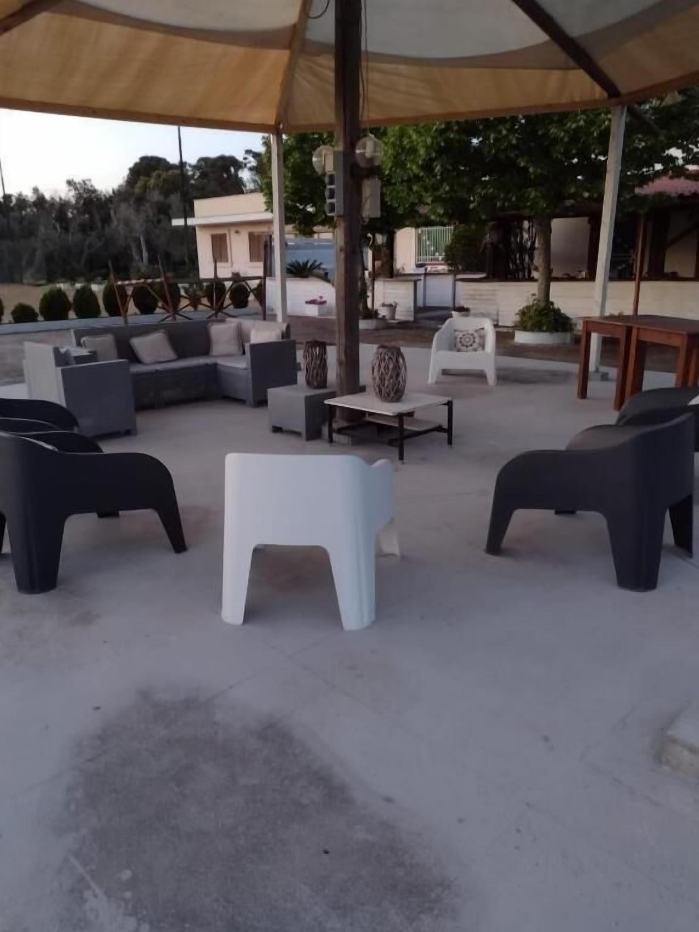An outdoor seating area with a canopy, sofas, and a coffee table.