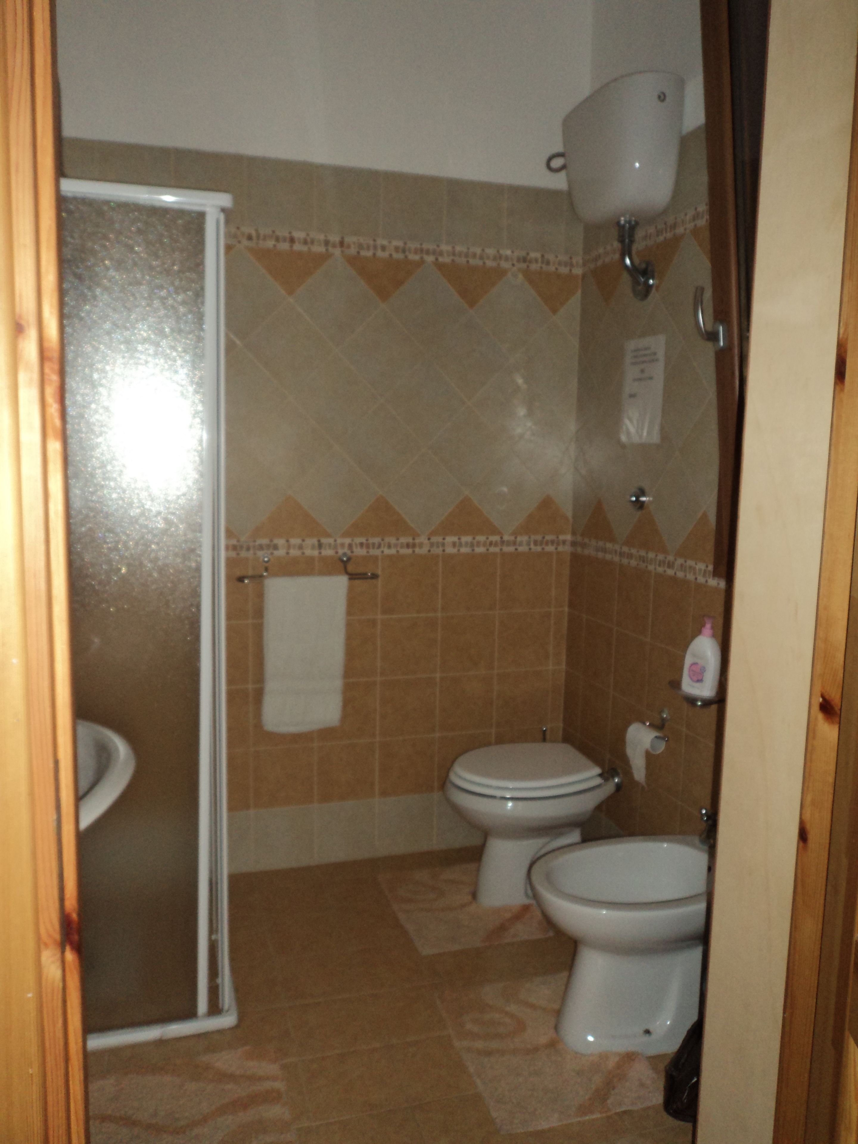 Un bagno con due servizi igienici, un lavandino e una doccia.