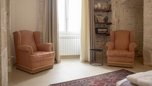 Una habitación con dos sillones, una mesita redonda y una alfombra estampada.