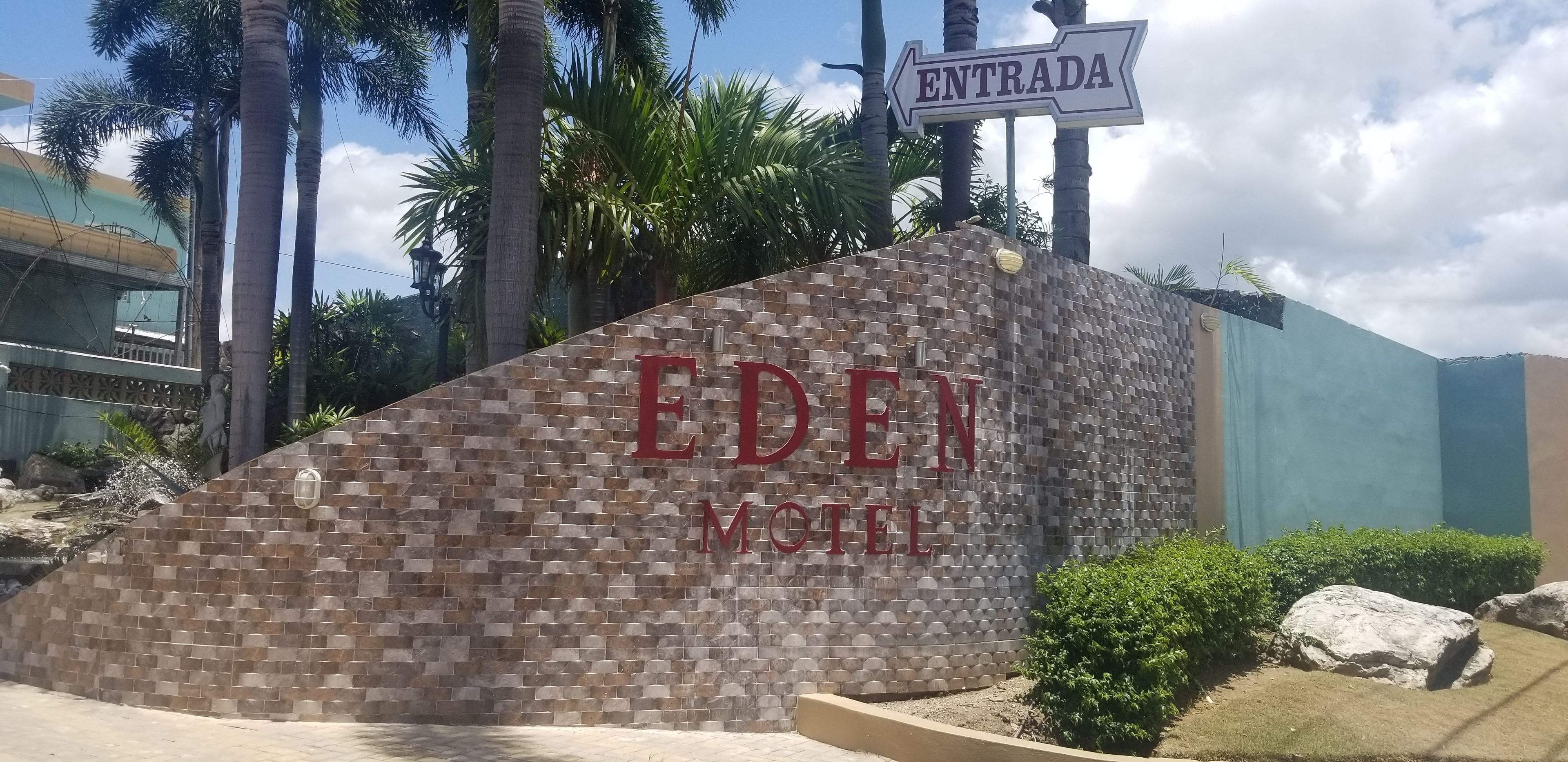 Un mur de pierre sur lequel on peut lire les mots « EDEN HOTEL » et une enseigne indiquant « ENTRADA ».
