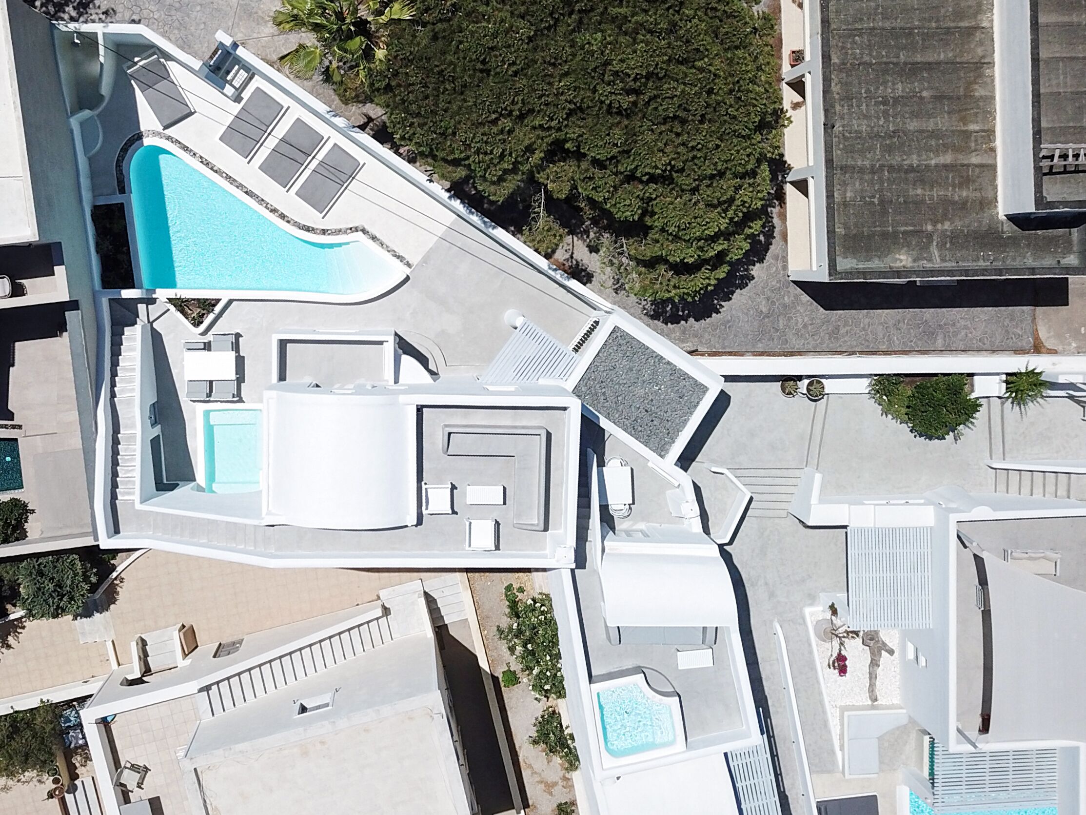 Vista aérea de un hotel con piscina, varias habitaciones y una zona de estacionamiento.