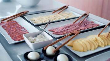 A table with various food items including sliced meat, pickled vegetables, and rice.