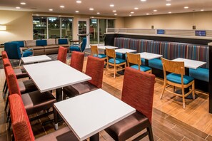 A modern dining area with booths and tables, featuring a mix of seating styles and a view of the outdoors. - TownePlace Suites by Marriott Ontario Chino Hills (Chino Hills)