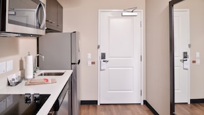 A modern kitchen with a microwave, refrigerator, sink, and stove.