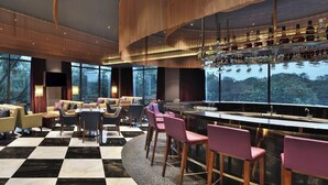 A modern bar area with a checkered floor, bar stools, and a wine display. - Courtyard by Marriott Madurai (Madurai)